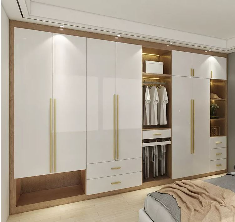 A stylish white swing wardrobe with integrated shelves and elegant gold handles.